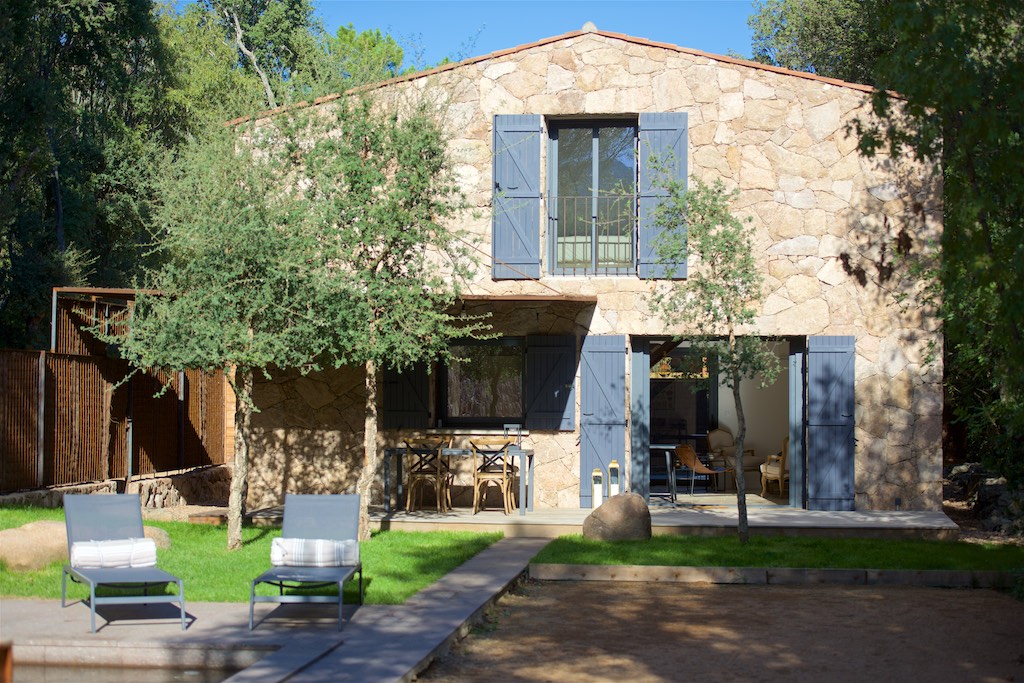 Villa en pierre à étage avec volets bleus et terrasse