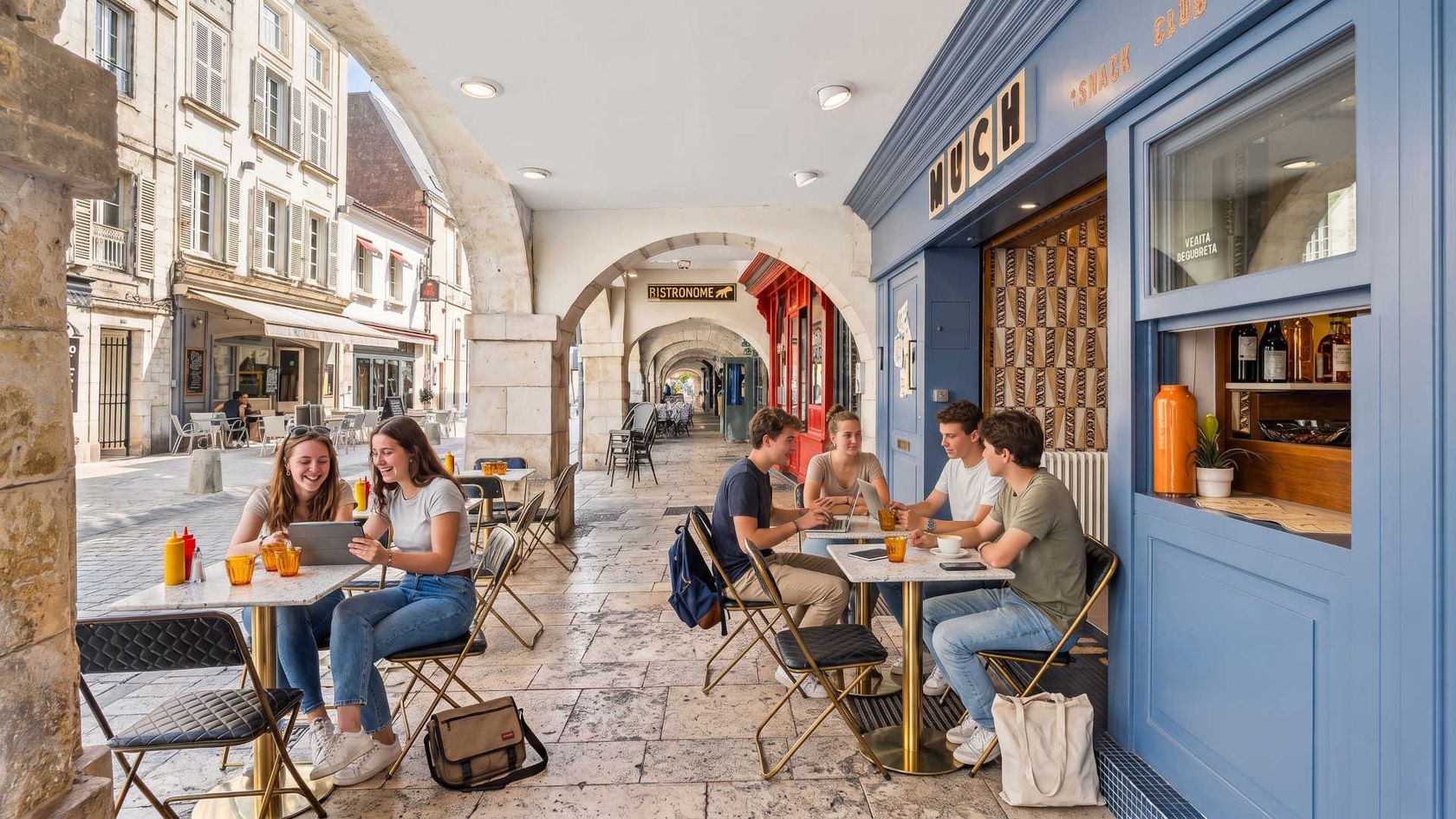 Étudiants en terrasse sous les arcades du centre-ville de La Rochelle